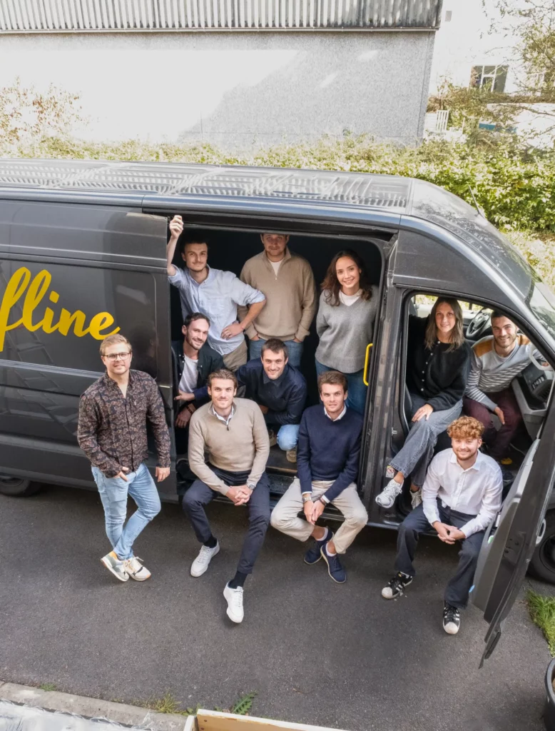 Photo de l’équipe Fline rassemblée autour d'une camionnette brandée au nom de l’entreprise, ambiance professionnelle et conviviale